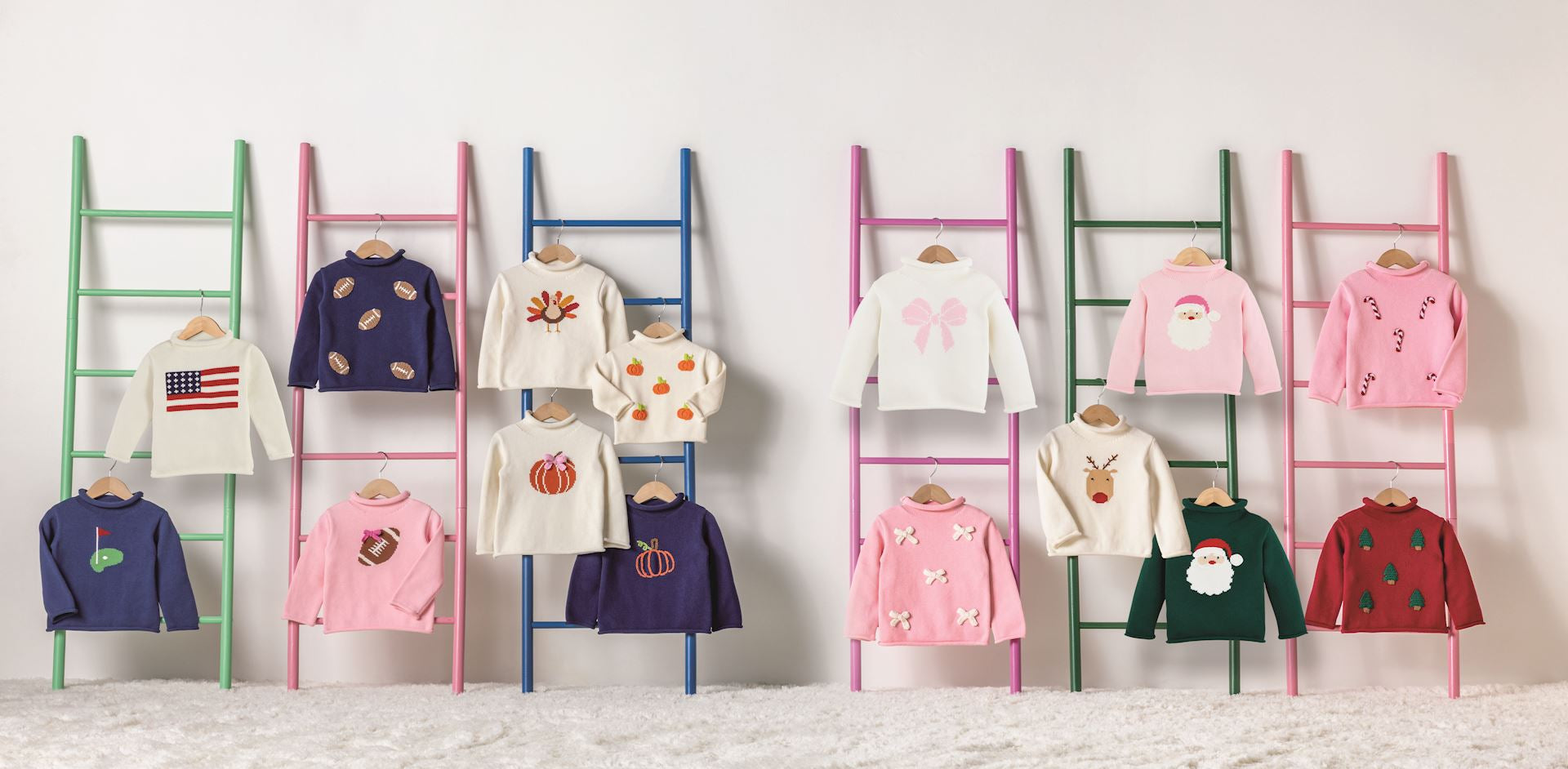 Mud Pie children's sweater range displayed on ladders