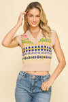 Woman wearing a patterned sleeveless top and jeans on a beige background