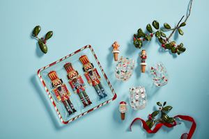 Decorative nutcrackers platter, mistletoe, wine glasses and bottle stoppers on a blue background