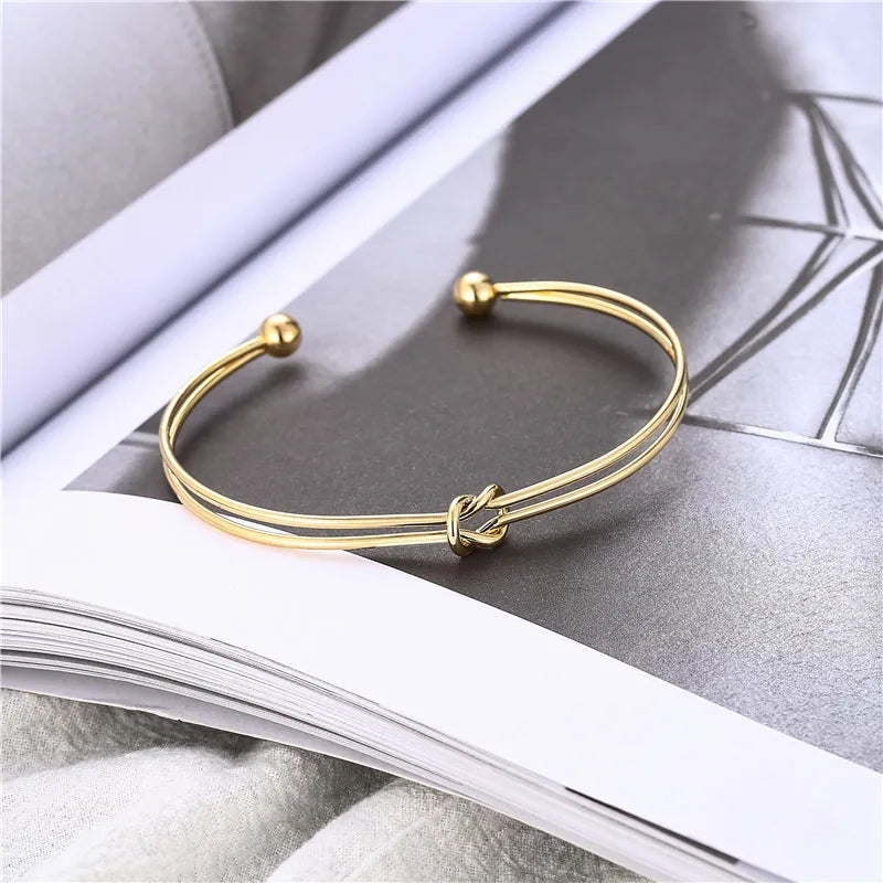Gold double-layer knotted open cuff bangle with love-knot center and round bead ends