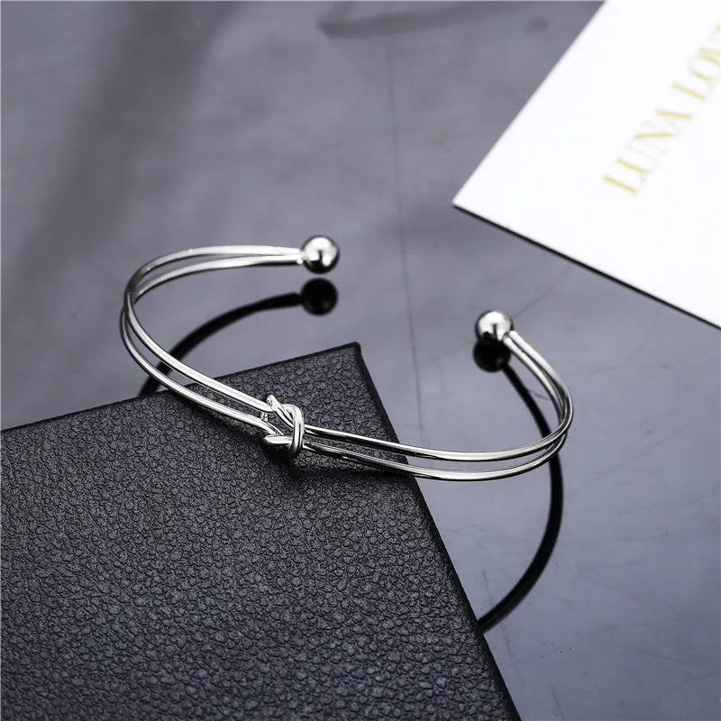 Silver double-layer knotted open cuff bangle with love-knot center and round bead ends