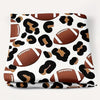 Patterned fabric with footballs and leopard print on a white background