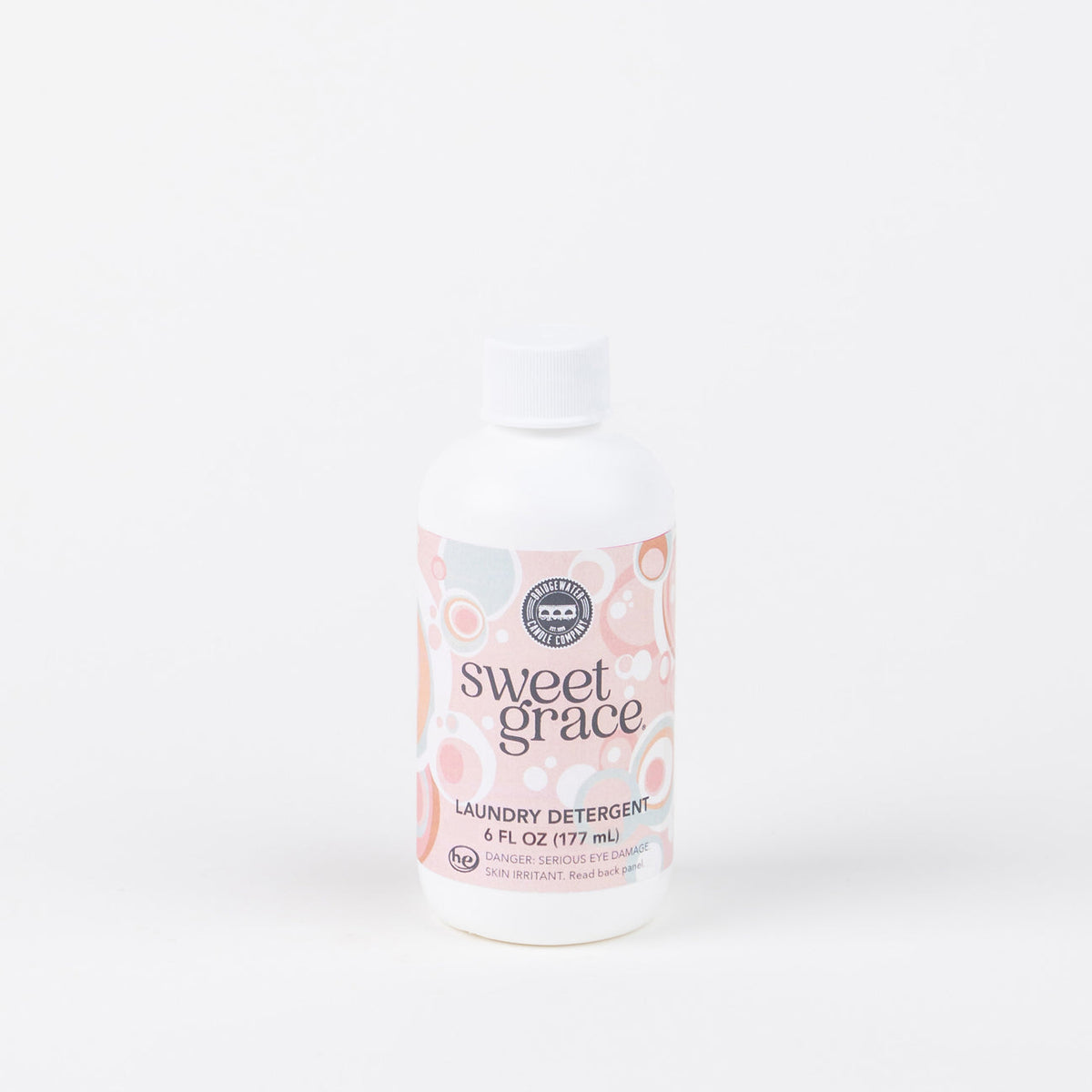 A bottle of Sweet Grace Laundry Detergent, 6 oz, with a white label featuring pink and orange floral designs.