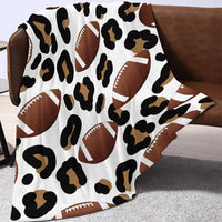 Leopard print blanket with football design draped over a brown chair.