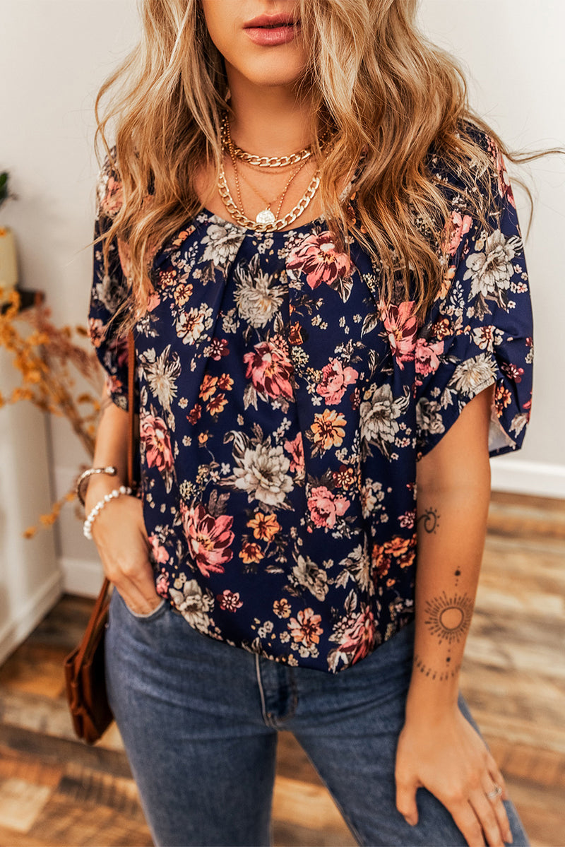 Woman wearing a floral blouse and jeans indoors