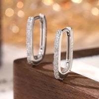 Macro view of sterling silver hoop earrings with white cubic zirconia stones