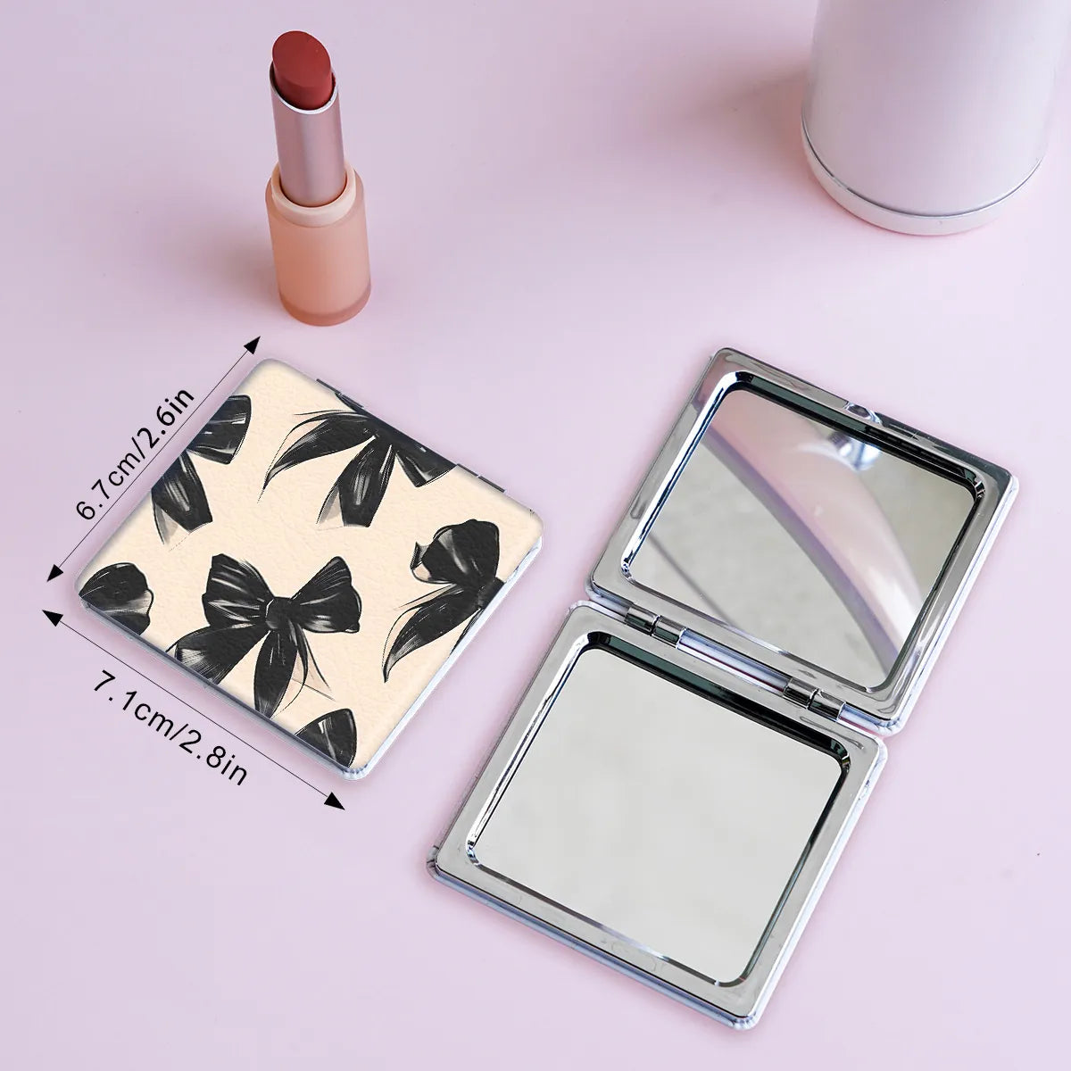 Open double-sided folding makeup mirror with black bow pattern and silver frame