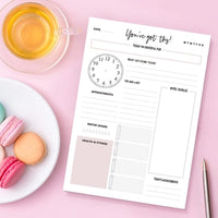 Minimalist daily planner notepad with hourly schedule and habit tracker