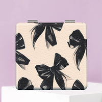 Beige PU leather folding compact makeup mirror with a black bow print