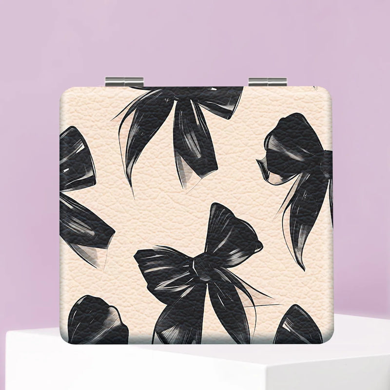 Beige PU leather folding compact makeup mirror with a black bow print