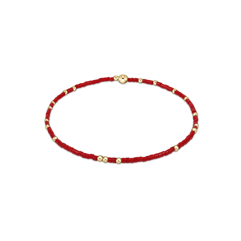 Red beaded bracelet with gold beads on a white background