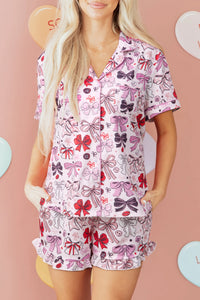 Woman wearing a pink pajama set with bow pattern on a pink background