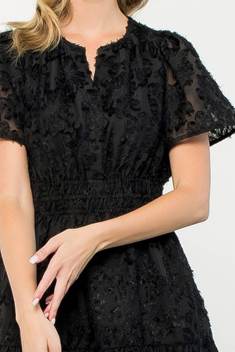 Black lace dress worn by a person on a white background