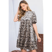 Woman wearing a leopard print dress against a white background