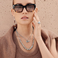 Model wearing Brighton layered silver necklaces styled with Contempo sunglasses