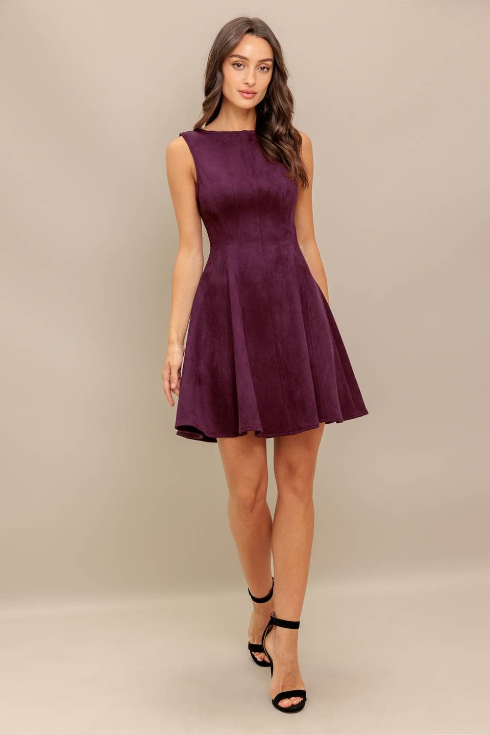 Woman wearing a purple dress against a beige background