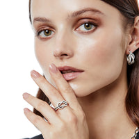 Model wearing a Brighton silver-plated knot ring paired with matching silver-plated knot hoop earrings