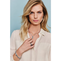 Model wearing a Brighton silver-plated pendant necklace with interlocking design and coordinating Brighton accessories