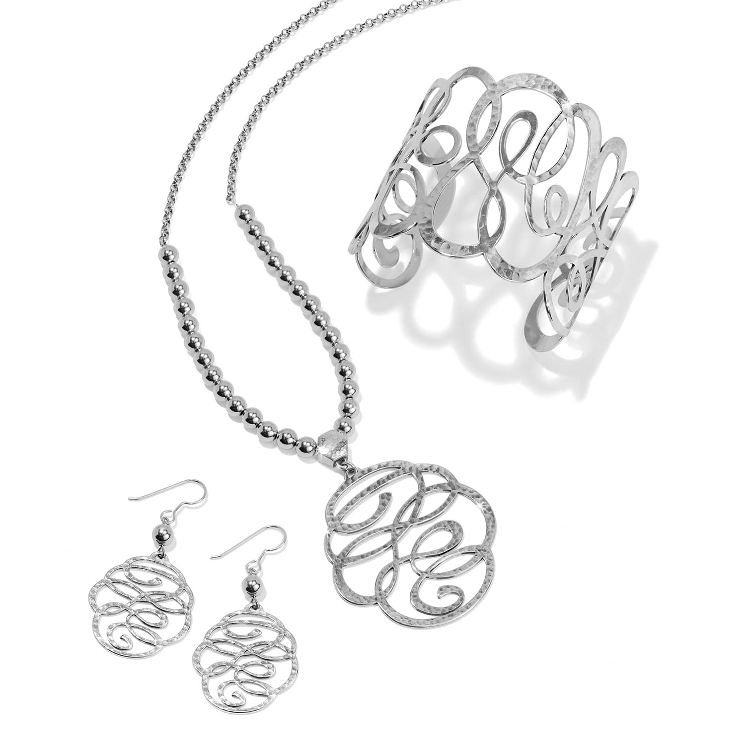 Brighton silver-plated jewelry set styled with hammered swirl pendant necklace, earrings, and cuff bracelet