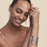 Model wearing a Brighton silver-plated hammered cuff bracelet with openwork swirl design