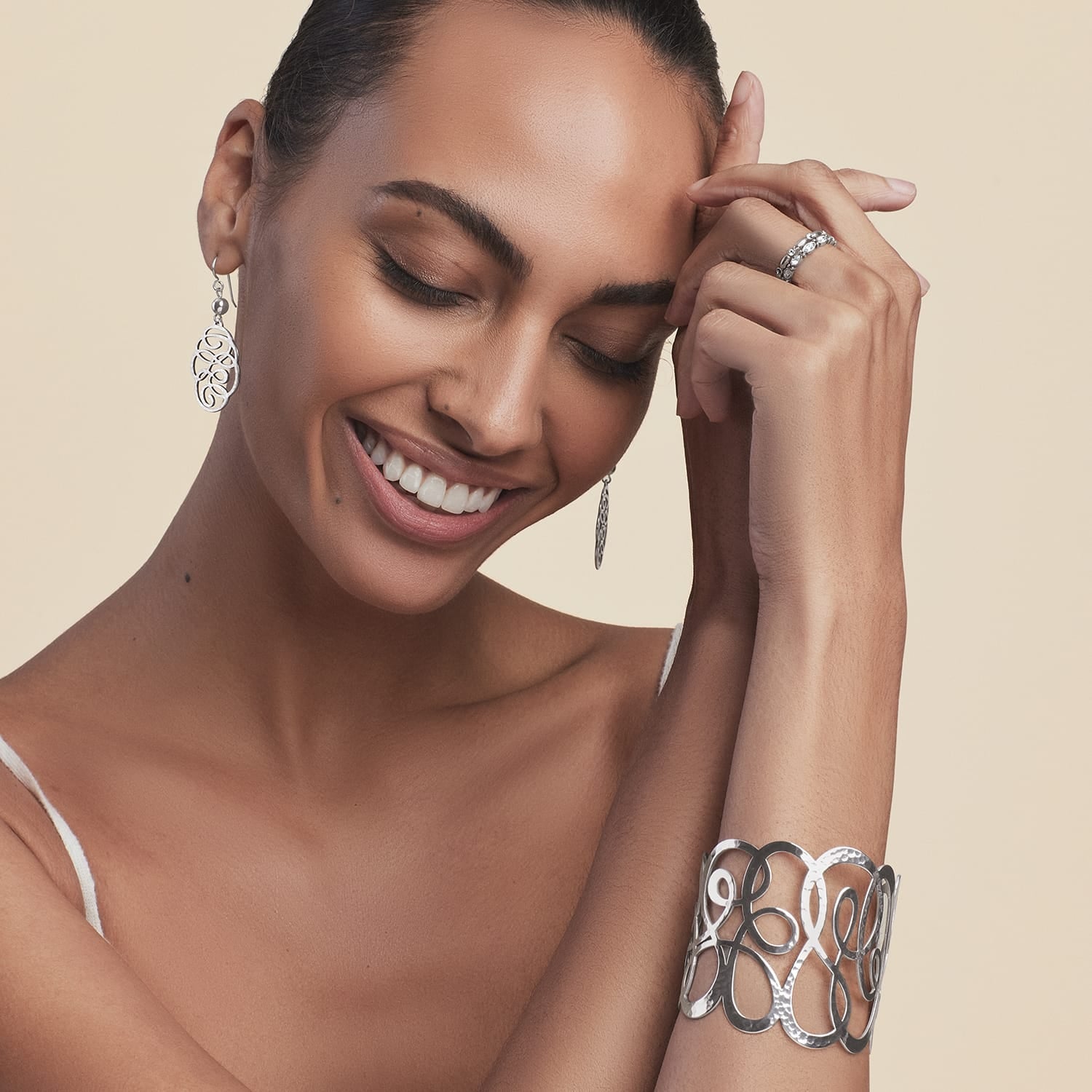Model wearing a Brighton silver-plated hammered cuff bracelet with openwork swirl design