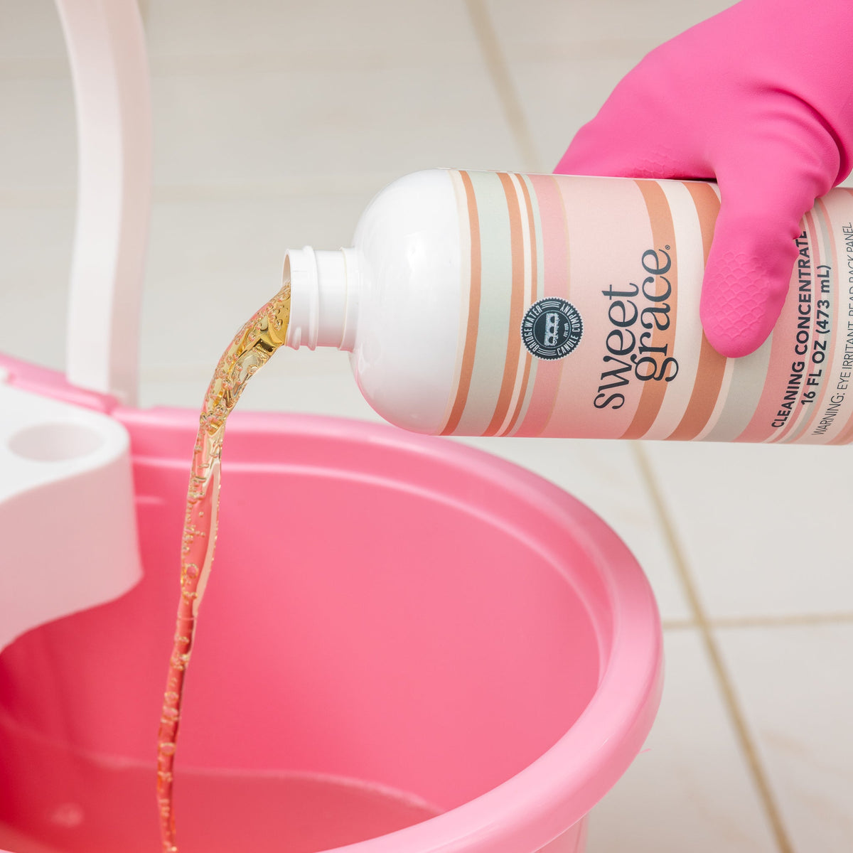 Sweet Grace Cleaning Concentrate poured into a pink cleaning bucket